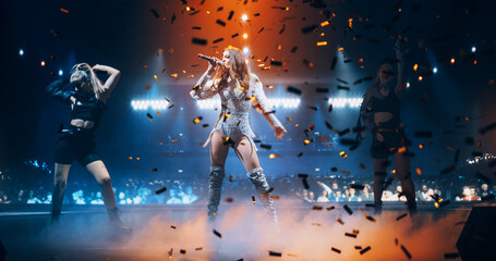 Portrait of Two Beautiful Female Pop Singers Performing on Stage. Action Camera Switching From One Performer to Another. Choreography and Stunning Visuals Make for Creative Atmosphere
