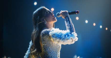 Music Contest: Beautiful Pop Music Artist Performing a Hit Song on Stage in Front of a the Camera. Her Charismatic Stage Presence and Lyrics Electrify the Diverse Music Fans