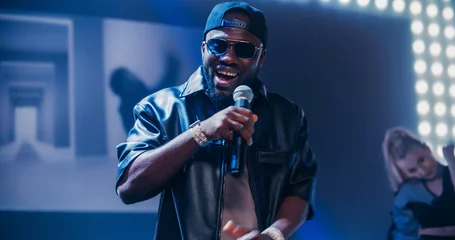 Fototapete Rund Minecraft Young Hip Hop Singer in Black Leather Jacket Performing a Solo Concert with a Show Girl on a Festival Stage. His Charismatic Stage Presence and Lyrics Electrify the Diverse Music Fans in Crowded Arena  © Gorodenkoff