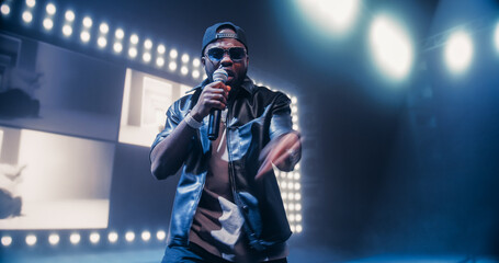 Hip Hop Concert with a Lively Performance: Young Talented Musician Performing a Show on Stage in...