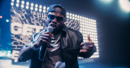 Creative Rap Artist Performing a Hit Song on Stage with a Striking Female Dancer, Inspiring a Large...