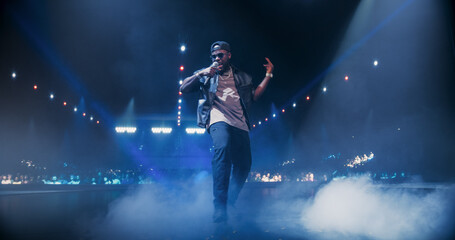 Creative Rap Artist Performing a Hit Song on Stage with a Striking Female Dancer, Inspiring a Large Audience in a Colorful Neon Concert Setting with Cinematic Lighting and Animated LED Screen