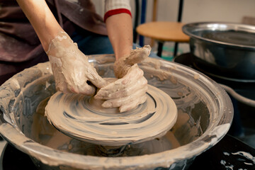 close up the clay modeling studio young girl hands giving shape to clay on a potter's wheel applied art clayware old craftsmanship teacher helps