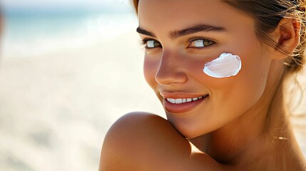 Close-up of a woman's face with a white cream on her cheek, smiling.