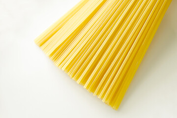 Uncooked spaghetti pasta on white background. Raw food. Cooking preparation for Spaghetti Bolognese and pasta menu.
