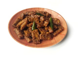 Oreg tempe or Indonesian food made from tempeh with soy sauce and spices on plate isolated on white background 