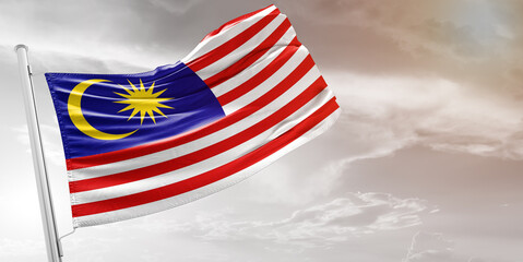 Malaysia national flag cloth fabric waving on beautiful grey Background.
