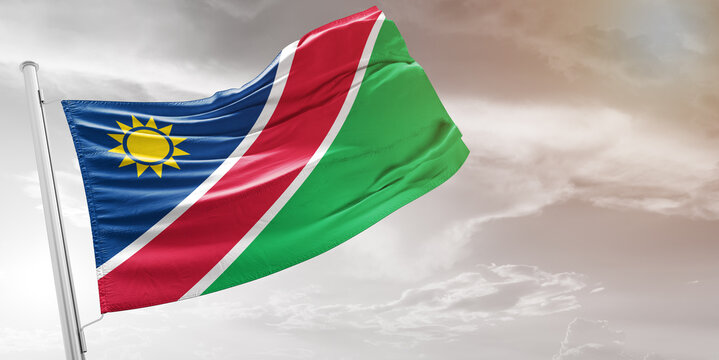 Namibia national flag cloth fabric waving on beautiful grey Background.