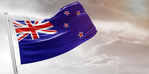 New Zealand national flag cloth fabric waving on beautiful grey Background.