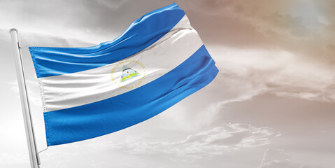 Nicaragua national flag cloth fabric waving on beautiful grey Background.