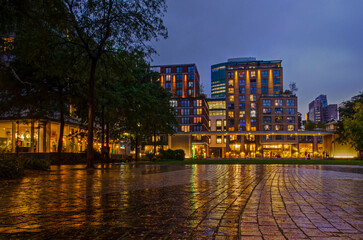 Rotterdam, The Netherlands, October 1, 2024: buildings around the square in front of the church reflect in the wet pavement during the blue hour