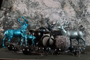 blue and black Christmas ornaments with silver accents, displayed alongside deer figurines.