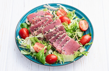 Salad with raw tuna , sesame and cherry tomatoes photography . Top view