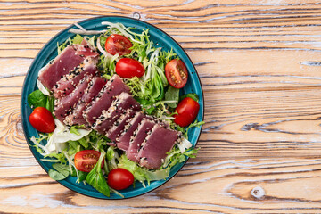 Salad with raw tuna , sesame and cherry tomatoes photography . Top view