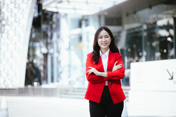 Stylish Asian businesswoman standing outdoors and confidently using tablet to plan finances and find digital solutions.