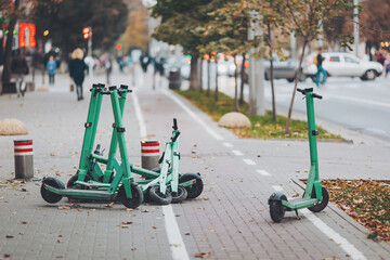 Public rental electric kickboard, parking of scooters on a street. scooters abandoned on the street interfere with pedestrians and vehicles. Scooter startups have flooded the city's streets © Cristina