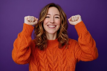 A woman wearing an orange sweater holds her hands up, possibly in a defensive or calming gesture