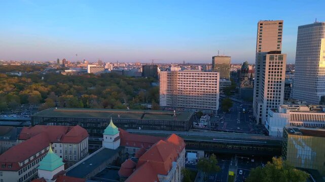 zoologischer garten train station and surrounding urban landscape in berlin, germany during sunset. Perfect aerial view flight rotation to left drone