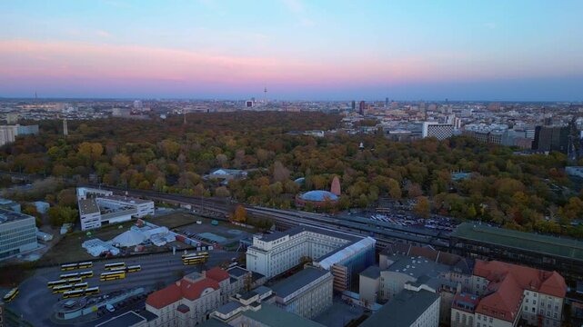 zoologischer garten train station and surrounding urban landscape in berlin, germany during sunset. Majestic aerial view flight descending drone
