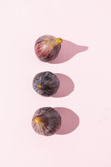 Overhead View of Three Fresh Figs on Light Pink Surface