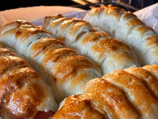 Appetizing fresh baked goods from the oven. Ruddy sausages in dough on a tray in the oven. Tasty...