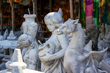 plaster humanoid sculptures stand in a row