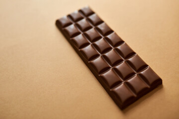 Chocolate, slab or sweet with candy in studio for dessert ingredient or sugar on a brown background. Closeup, cocoa or block with snack for unhealthy diet, baking or antioxidant on mockup space