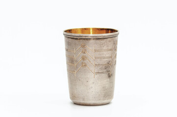 Small silver gilded antique vintage glass, isolated on white background. Metal glass with engraving pattern.