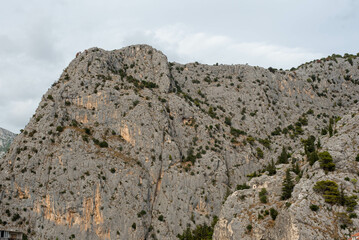 Stunning view of the mountains surrounding the city of Omis, Croatia, with a beautiful landscape blending rocky peaks and lush greenery.