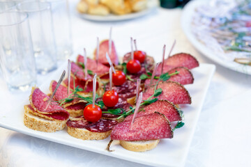 Canape with Italian salami, french baguette and ripe cherry tomatoes