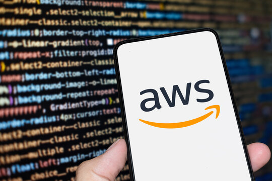 AWS (Amazon Web Services) logo sign on the smartphone screen with code background. London, UK, 11.14.2024