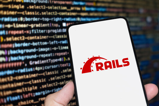 Ruby on Rails logo sign on the smartphone screen with code background. London, UK, 11.14.2024