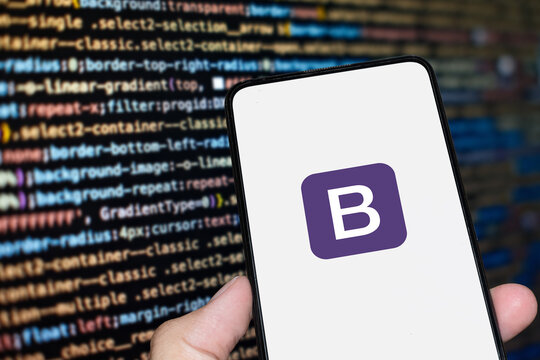 Bootstrap logo sign on the smartphone screen with code background. London, UK, 11.14.2024