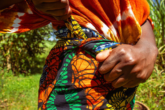 A close of  on an African woman fastening her wrapper on her waist