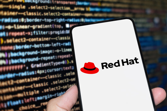 Red Hat logo sign on the smartphone screen with code background. London, UK, 11.14.2024