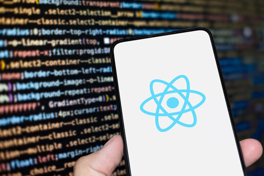 React logo sign on the smartphone screen with code background. London, UK, 11.14.2024