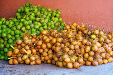 Pile of coconut green and brown nuts stacked after harvesting in storage warehouse