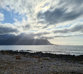 evocative image of a beach with the promontory and clouds in the background in Sicily
