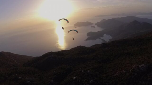 Extreme paragliders flying together at sunset. Oludeniz, Turkey.