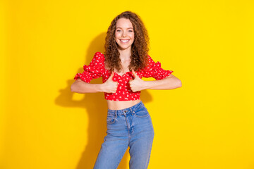 Photo of charming positive woman wear red top showing two thumbs up empty space isolated yellow color background