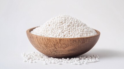 Close-up of white sago pearls in a wooden bowl, showcasing texture and culinary potential. Ideal for food blogs, health websites, or recipe articles.