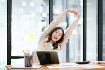 Businesswoman stretching at her desk during a break in the office