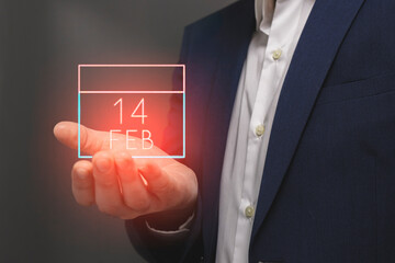 Hand of a businessman showing calendar date February 14 on a virtual screen. Technology and Valentine's Day concept.