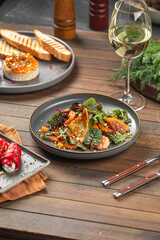 Portion of salad with persimmons and shrimps on wooden served table