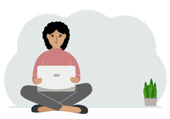 A woman sits cross-legged in his hands holding a laptop. The concept of work, education, reading, watching videos.