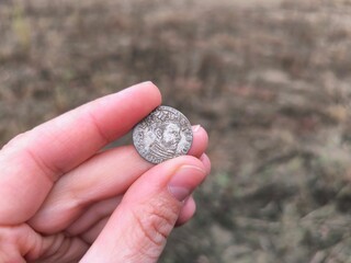 An ancient coin in your hands. An old silver coin