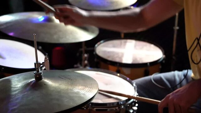 Musician plays a repetitive rhythm on a snare drum and hi-hat, creating an energetic and engaging sound