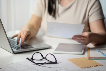 Woman paying bills online using laptop at home. Bill paying concept. Digital payment using internet