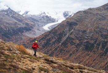 A man hiking in the mountains above Pontresina, in autumn.