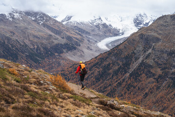 A man hiking in the mountains above Pontresina, in autumn.